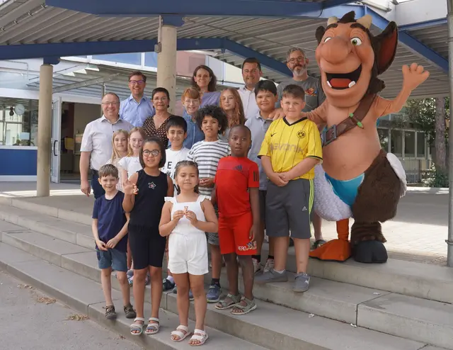 Stellvertretend für alle Oberkircher Grundschulen erhielten die Kinder der Johann-Wölfflin-Grundschule einen Mini-Simpli und eine Autogrammkarte des Heimattage-Maskottchens. Von links: Fachbereichsleiter Mathias Benz, Oberbürgermeister Gregor Bühler, Rektorin Eva Woelki, Gabriele Schindler (Geschäftsstelle Heimattage), Michelangelo Liccione (Sparkasse Offenburg/Ortenau Nord), Gerd Dörflinger und das Heimattage-Maskottchen Simpli | Foto: Tamara Fritsch/Stadt Oberkirch
