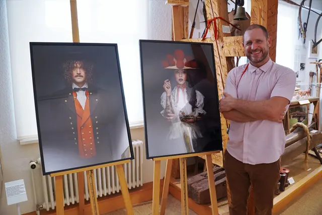 Fotograf Sebastian Wehrle mit zwei seiner Trachtenporträts. Links ist die eigens für die Heimattage Baden-Württemberg geschaffene Fotografie einer Renchtäler Männertracht zu sehen, die bei der Vernissage erstmals präsentiert wurde.  | Foto: Denise Burkart/Stadt Oberkirch