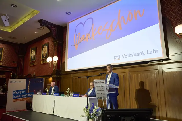 Aufsichtsratsvorsitzender Bernd Neugart (Bildmitte) begrüßt die Vertreterinnen und Vertreter und weitere Gäste, insgesamt rund 500 Teilnehmer. Vorstandsvorsitzender Peter Rottenecker (rechts) und Vertriebsvorstand Reiner Richter (links) berichten über das Geschäftsjahr 2025 und die weitere Ausrichtung der Volksbank Lahr. | Foto: Michael Bode/Volksbank Lahr
