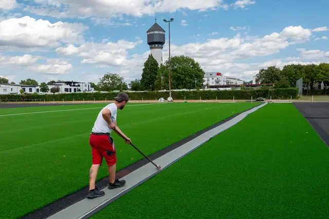 Für die neuen Spielfeldlinien schneiden Fachkräfte zuerst schmale Bahnen in den Kunstrasen, um anschließend passgenau Markierungsstreifen einzusetzen. | Foto: Stadt Kehl/Gabriele Dasch