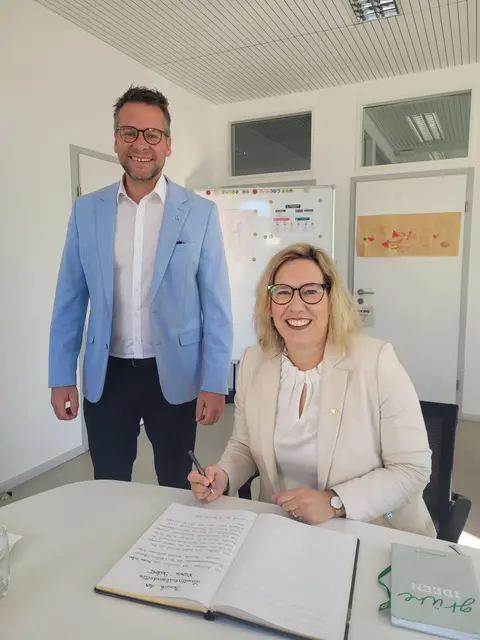 Die Offenburger Landtagsabgeordnete Maren Seifert (Grüne) trägt 
sich auf Einladung des Bürgermeisters Tobias Uhrich in das Goldene Buch der Gemeinde Neuried ein.  | Foto: Abgeordentenbüro Maren Seifert